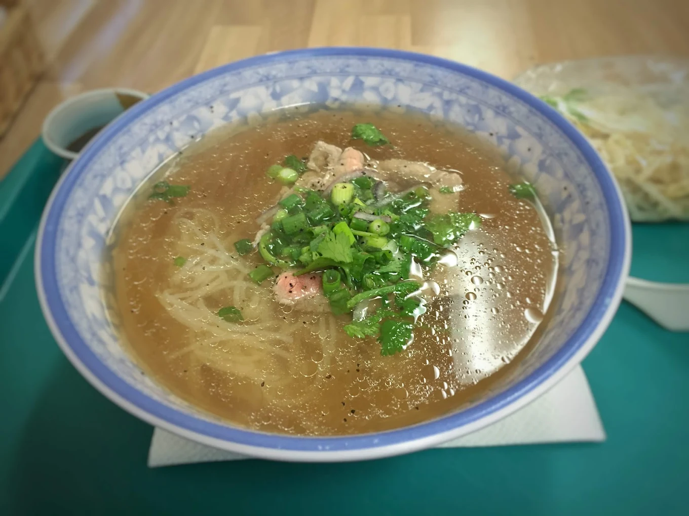 Freshly prepared Vietnamese Pho noodle soup and sandwich combo on a tray.